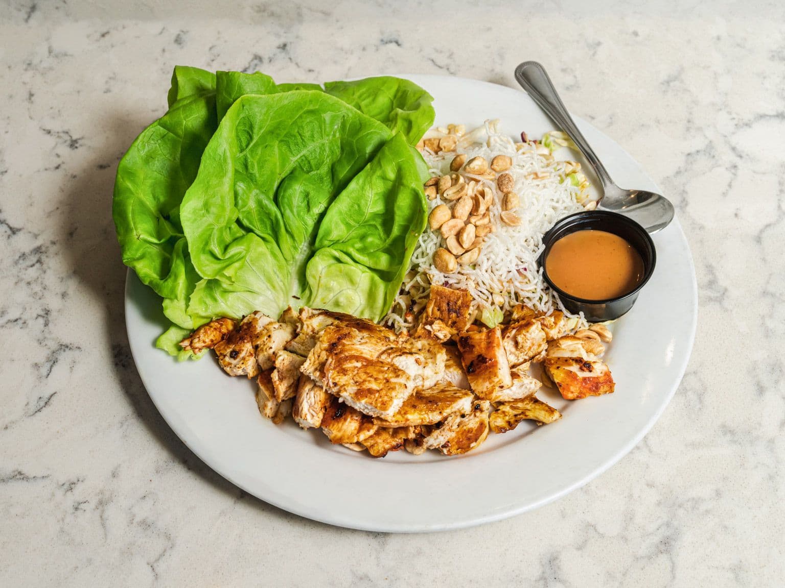 Grilled chicken with butter lettuce cups, rice noodles, peanuts and a dipping sauce.