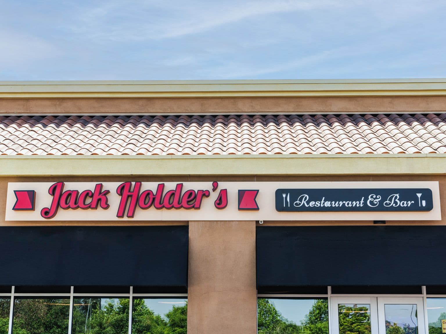 The Jack Holder's storefront: a red script sign and a Restaurant & Bar sign above dark awnings, under a tiled roof.